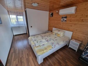 トゥルダにあるCasa Baciuの木製の部屋にベッド1台が備わるベッドルーム1室があります。