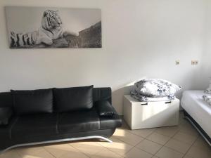 a living room with a couch and a picture of a tiger at 1-ZKD mit EBK, modern und barrierefrei, SELF-CHECK-IN in Ittlingen