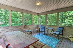 un porche grillagé avec une table et des chaises dans l'établissement Deck, Hot Tub and Game Room Lake Harmony Home, à Lake Harmony