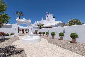 un edificio blanco con un patio con macetas en CORTIJO LA MINA - Luxury Villa Conil, en Conil de la Frontera