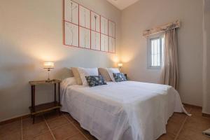a bedroom with a large white bed with a window at Cortijo La Mina by LaJudería de Vejer - Luxury Villa in Conil de la Frontera