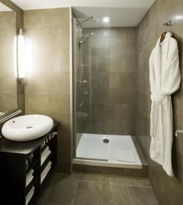 a bathroom with a bath tub, toilet and sink at Mercure Quimper Centre in Quimper