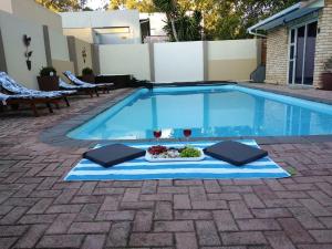 a pool with a tray of food and a plate of food at Phumanathi Guesthouse in Summerstrand