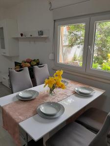 a dining room table with plates and yellow flowers on it at Apartments Mate in Split