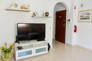 a flat screen tv sitting on top of a white entertainment center at Edificio Tomás 1 in Ferragudo