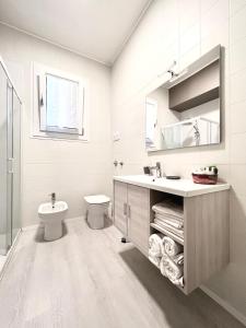 a white bathroom with a sink and a toilet at Nanda house in Piove di Sacco