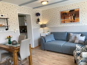 a living room with a blue couch and a table at Gästehaus Daheim in Lohme