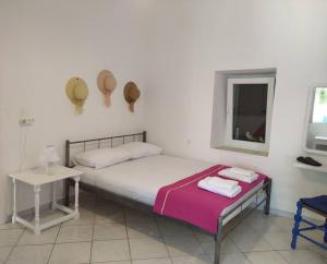 a bedroom with a bed and a table and a window at Το σπίτι της Μαργαρίτας στην παραλία in Nea Stira