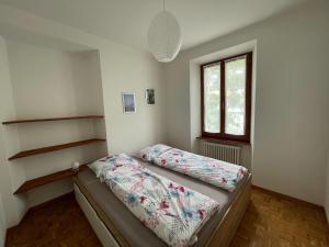 Schlafzimmer mit einem Bett und einem Fenster in der Unterkunft Residence Gaggiole, apartment 3 in Gordola