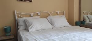 a white bed with white sheets and pillows at Jeremilla in Spanokhórion