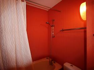 La salle de bains rouge est pourvue d'une baignoire et de toilettes. dans l'établissement Studio Chamrousse, 1 pièce, 4 personnes - FR-1-549-75, à Chamrousse