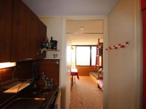 une cuisine avec un évier et un couloir menant à une chambre dans l'établissement Studio Chamrousse, 1 pièce, 4 personnes - FR-1-549-75, à Chamrousse
