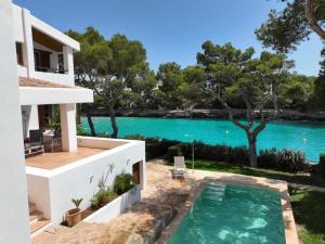 una casa con piscina junto a un cuerpo de agua en Villa Sa Pau, en Santanyí