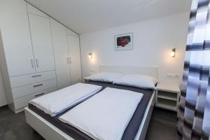niewielka sypialnia z 2 łóżkami i szafką w obiekcie Villa Lilli - Appartements Kroatien w Crikvenicy