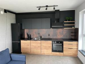 a kitchen with a sink and a black refrigerator at Apartament Husarska in Rumia