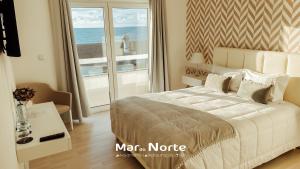a bedroom with a bed with a view of the ocean at Beach Residence Mar do Norte in Ribamar