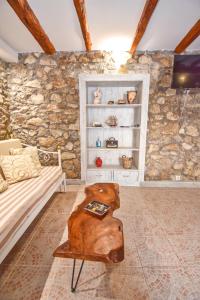 ein Wohnzimmer mit einem Sofa und einem Tisch in der Unterkunft The Stone suite in Moraḯtika