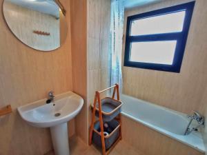 W łazience znajduje się umywalka, wanna i lustro. w obiekcie Estudio Infinity con parking w mieście Sierra Nevada +26 zdjęć