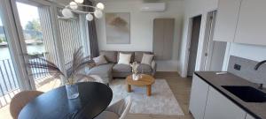 a kitchen and living room with a couch and a table at Apartamentai AQUA in Palanga