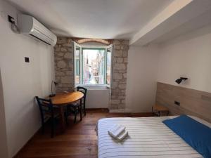 a bedroom with a bed and a table and a window at The Heart of Hvar in Hvar