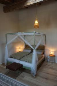 Bett mit Baldachin in einem Zimmer mit Beleuchtung in der Unterkunft Alte Brennerei Schloss Zehista OG Akelei in Pirna