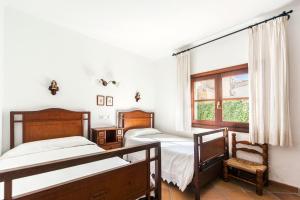 sypialnia z dwoma łóżkami i oknem w obiekcie Villa Amorós w Cala Ratjada