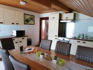 a kitchen with a wooden table with chairs and a dining room at Haus Manuela am Pressegger See in Egg