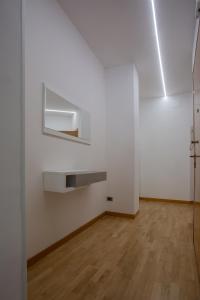 Zimmer mit weißen Wänden und Holzböden in der Unterkunft Casa vacanze san salvo centro in San Salvo
