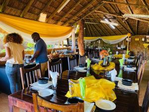 a man and woman standing at a table in a restaurant at Xisaka Guest House in Giyani