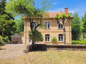 een groot geel huis met bomen ervoor bij Villa Benjamine - Parc Haut Languedoc in Lamalou-les-Bains