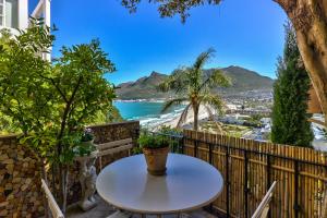 a table on a balcony with a view of the ocean at Dar El Hout in Hout Bay