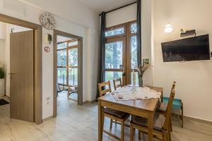 uma sala de jantar com uma mesa e cadeiras e uma televisão em PALOMIA A em Split