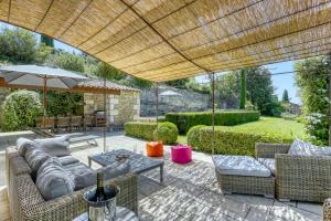 a patio with a couch and chairs and an umbrella at Villa Vermentine in Gordes