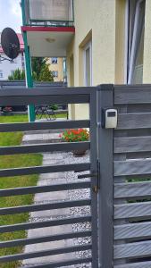 a fence with a door and flowers on it at Apartament Marco in Koszalin