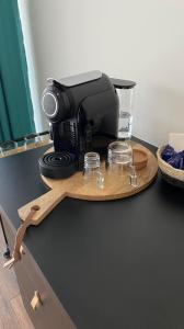 eine schwarze Kaffeemaschine auf einem Holztablett mit Brille in der Unterkunft Zambujal Suites in Sesimbra