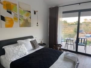 a bedroom with a bed and a view of a patio at Zambujal Suites in Sesimbra