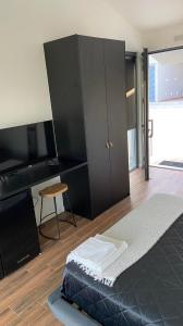 a bedroom with a large black cabinet and a desk at Zambujal Suites in Sesimbra