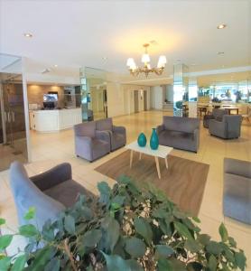 un ampio soggiorno con divani e tavolo di Hotel Vip´s a Mar del Plata
