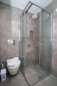 uma casa de banho com uma cabina de duche em vidro e um WC. em Cesurlar Hotel em Cesme