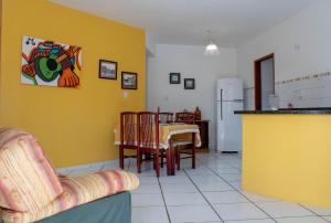 a kitchen and dining room with a table and yellow walls at EXCLUSIVE - AMPLO, FAMILIAR E PRÓXIMO DE TUDO in Cabo Frio