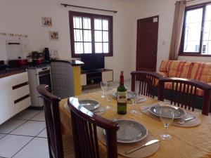 una mesa de comedor con una botella de vino. en EXCLUSIVE - AMPLO, FAMILIAR E PRÓXIMO DE TUDO, en Cabo Frío