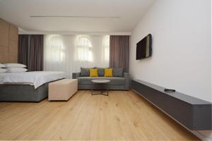 a bedroom with a bed and a couch and a tv at Miss Saray in Sarajevo