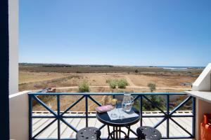 a table on a balcony with a view of the ocean at Sunshine Apartment in Armação de Pêra