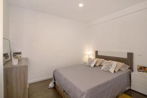 a bedroom with a bed and a white wall at Sunshine Apartment in Armação de Pêra