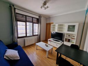 a living room with a blue couch and a table at Apartamento ideal Florida in Vitoria-Gasteiz