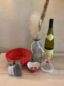 a bottle of wine and a bowl and a bottle of wine at Houssen/Colmar: « Chez Lin’Doux », le Nid Alsacien in Houssen