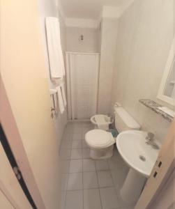 a white bathroom with a toilet and a sink at Hotel Vip´s in Mar del Plata