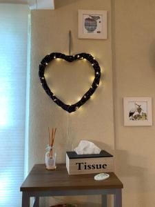 a heart shaped sign on a wall next to a table at Houssen/Colmar: « Chez Lin’Doux », le Nid Alsacien in Houssen +9 photos