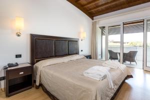 ein Schlafzimmer mit einem großen Bett und einem Balkon in der Unterkunft Hotel Smeraldo in Lignano Sabbiadoro