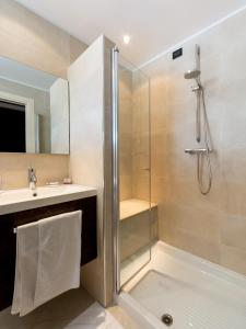 ein Bad mit einer Dusche und einem Waschbecken in der Unterkunft Hotel Smeraldo in Lignano Sabbiadoro